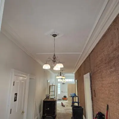 Hallway with exposed brick wall and new lighting, interior remodel