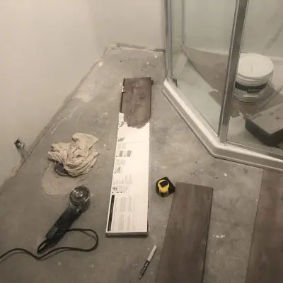 Wood-look plank flooring going in next to shower, bathroom remodel